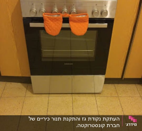 תנור גז עם ארבעה מבערים וכפפות כתומות